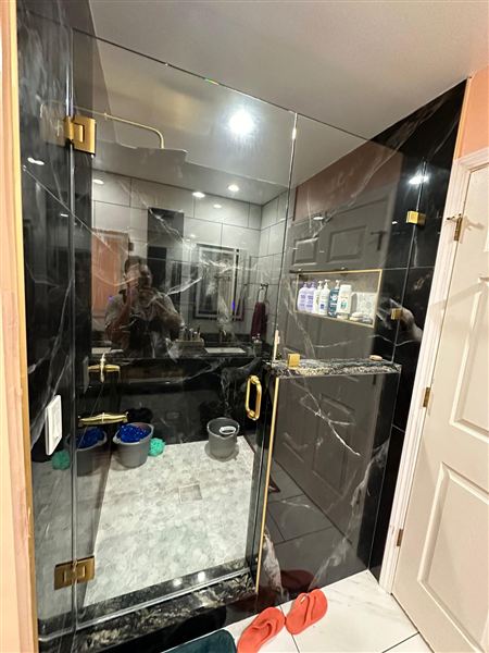 Glass shower black marble tile gold hardware